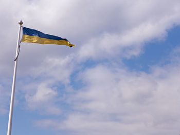 Low angle view of flag against cloudy sky