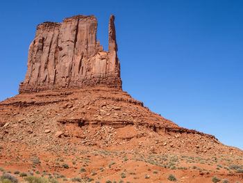 Low angle view of rock formation against clear blue sky