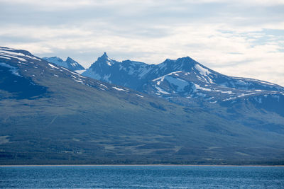 Lake by snowcapped mountain 