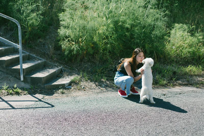 Woman playing dog on road