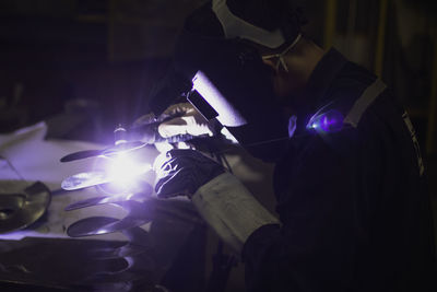 Side view of man welding at workshop