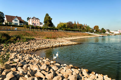 Scenic view of river by buildings against sky