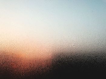 Sky seen through wet glass window