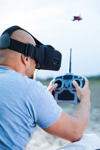 Man flying drone while wearing virtual reality simulator