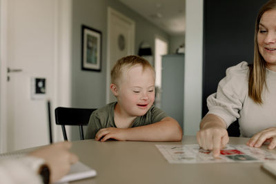 Mother teaching boy with down syndrome at home