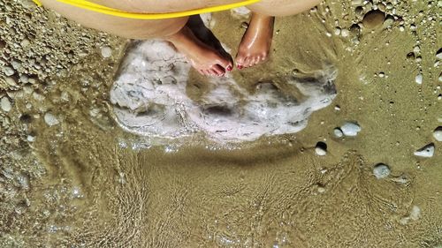 Low section of child standing on beach