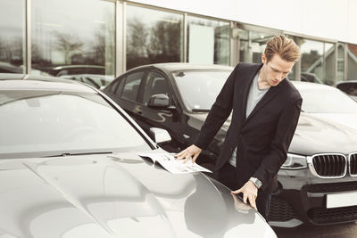 Man examining car outside showroom