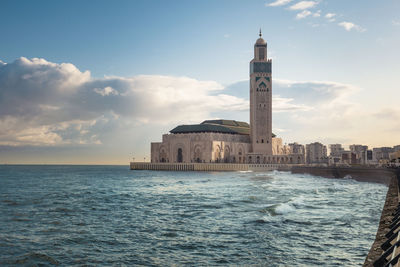 View of hassan ii mosque between water and sky - casablanca, morocco