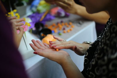 Cropped image of woman making crafts at table