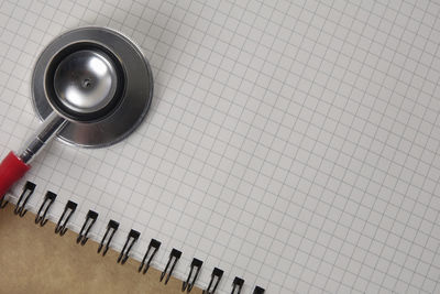 Directly above shot of stethoscope on spiral notebook