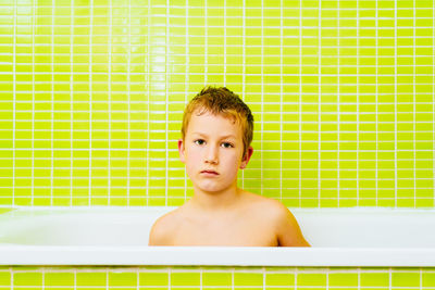 Portrait of shirtless boy in bathtub