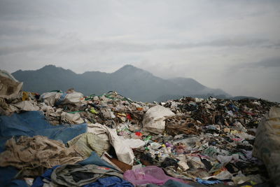 Stack of garbage on mountain range against sky