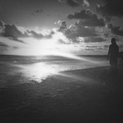 People standing on beach against sky