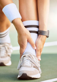 Low section of man tying shoelace