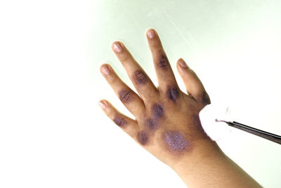 Close-up of woman hand over white background