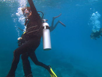 Low angle view of scuba divers swimming in sea