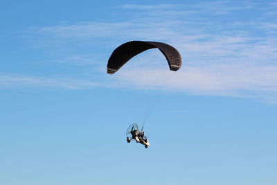 Person paragliding against sky