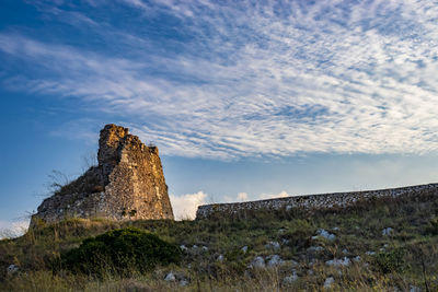 Low angle view of stone wall against sky