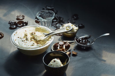 Ice cream in bowls with peanut butter cupcakes and chocolates on table