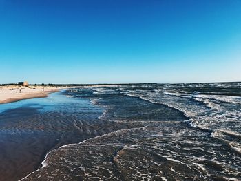 Scenic view of beach against clear blue sky