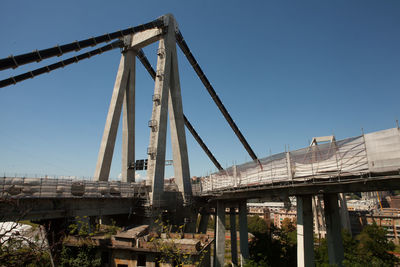 Low angle view of bridge against clear blue sky