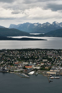 Aerial view of townscape and mountains against sky