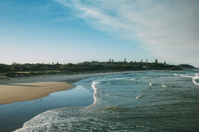 Scenic view of beach against cloudy sky