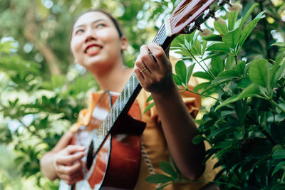 Portrait of a smiling young woman holding plant
