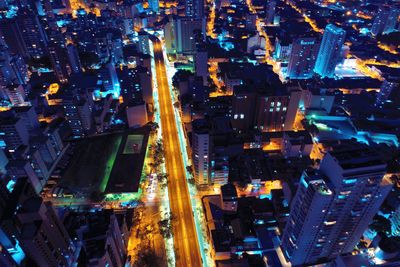 High angle view of illuminated street amidst buildings at night