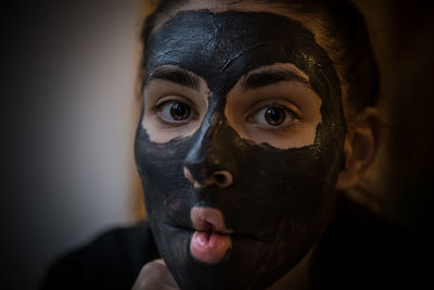 Close-up portrait of young woman with facial mask