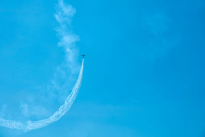 Overhead flying aircraft. aircraft in formation during an aerobatics display as they loop and roll