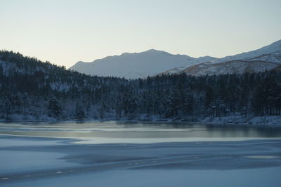 Scenic view of lake and mountains against clear sky