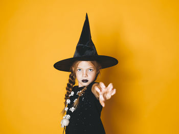 Portrait of woman standing against orange background