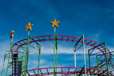 Low angle view of ferris wheel against blue sky