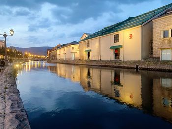 Canal amidst buildings against sky