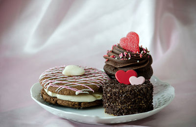  chocolate whoopee pie,  a chocolate cupcake with a heart and a cappuccino cake with candy hearts