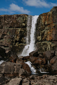 Scenic view of waterfall against sky