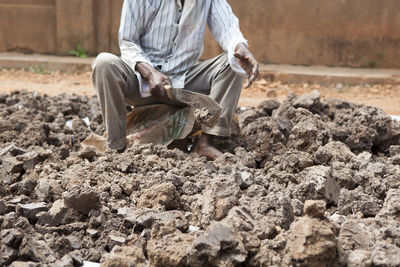 Close-up of man working in mud