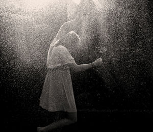 Woman spraying water through gardening hose