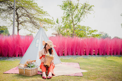 Rear view of woman with umbrella standing on field