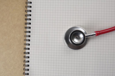 Directly above shot of stethoscope on spiral notebook