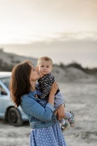 Rear view of mother and daughter standing outdoors