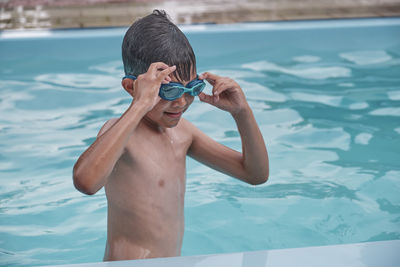 Full length of shirtless boy swimming in pool