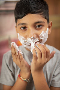 Close-up portrait of boy holding camera