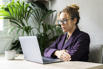 Businesswoman using laptop at table