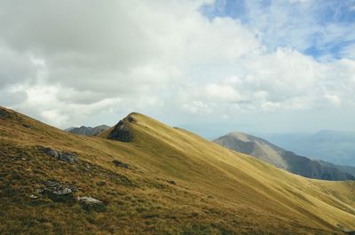 Scenic view of mountains against cloudy sky