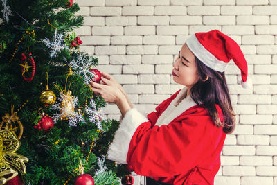 Midsection of woman with christmas tree during winter