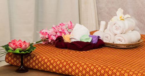Close-up of towels and flowers on mattress