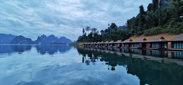 Scenic view of lake by buildings against sky