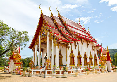 Traditional temple by building against sky